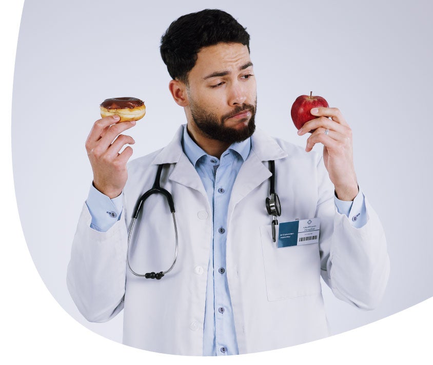 Doctor holding an apple and a donut on hands