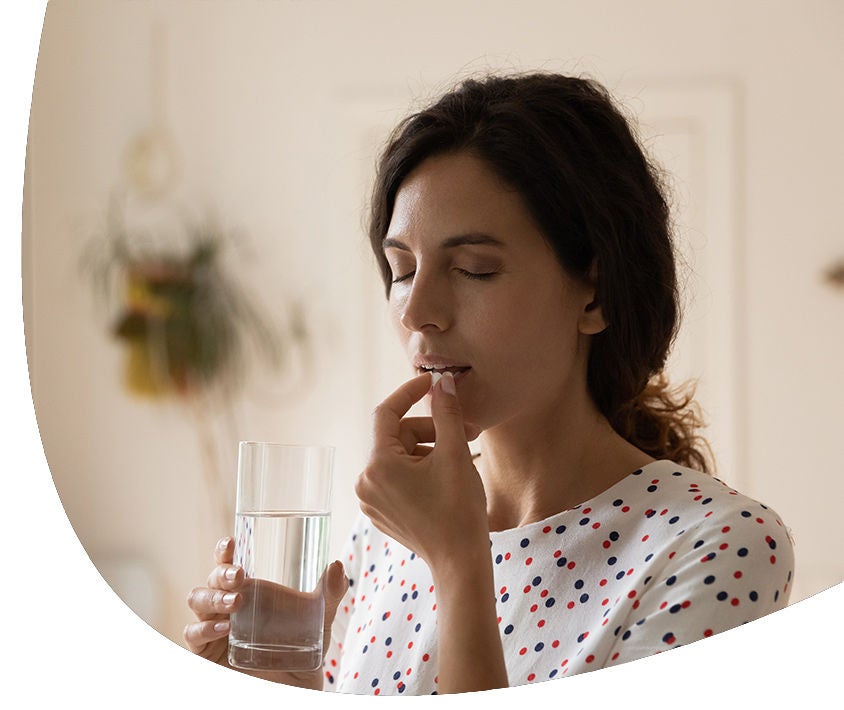 Woman taking a pill to heel 